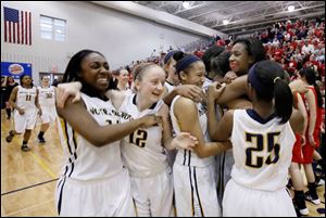 Notre Dame's Tierra Floyd (31) surrounded by teammates celebrate defeating Wadsworth 51-42 during the Division I girls basketball regional final.