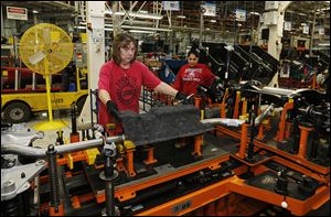 Ruth Jenkins of Erie, Mich., left, and Tonya Colbert of Toledo work at the Toledo Assembly complex, where employees have been putting in 60-hour weeks.