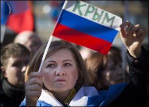 A woman holds a Russian flag with the word reading Crimea as about 1,000 demonstrators gathered to support Russians in Crimea in Moscow, Russia, today.
