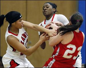 Rogers’ Jasmyne Smith, left, and Sasha Dailey battle Bellevue’s Jenna Strayer in the Division II regional championship. The Rams (24-4) advanced to the state tournament for the first time in school history.