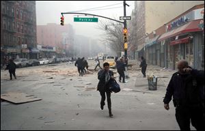People run after an explosion and building collapse in the East Harlem neighborhood of New York, Wednesday.