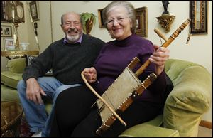 Abraham Sallock sits with Manira Saide-Sallock, holding her father’s rababa, a stringed instrument, in their Oregon home. Ms. Saide-Sallock’s father, Mohammed, lived in the Little Syria district in the 1940s.