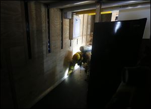 Tim Leeper of the Rawson Fire Department crawls through an ‘apartment’ as he seeks a ‘victim’ during firefighter training.