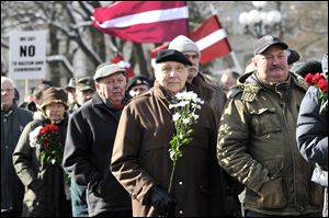 People carry Latvian flags as they march to the Freedom Monument in Riga. About 1,500 took part. A government minister was sacked after saying he would march.  