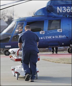 A paramedic wheels a bed to a Life Flight helicopter to transport a vehicular accident victim to the University of Toledo Medical Center.