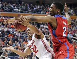 Dayton's Dyshawn Pierre (21) knocks the ball away from Ohio State's Lenzelle Smith Jr. (32) today in Buffalo, N.Y.