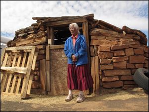 Navajo elder Stella Peshlakai Smith, 89, stands outside a traditional dwelling on her homestead at Wupatki National Monument in northern Arizona. 