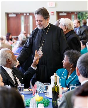 Metropolitan Nicholas of Detroit, center, talks with Norm, left, and Ora Bell, the parents of former mayor Mike Bell.