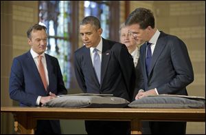 U.S. President Barack Obama, center, views the Act of Abjuration, widely considered to be the source document for the U.S. Declaration of Independence, during a tour of the Rijksmuseum with Museum Director Wim Pijbes, left, Prime Minister of the Netherlands Mark Rutte, right, and Mayor of Amsterdam Eberhard van der Laan today in Amsterdam.