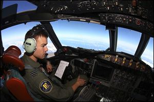 Flight Lt. Russell Adams looks out from the cockpit on board a Royal Australian Air Force AP-3C Orion Wednesday, during a search for the missing Malaysia Airlines Flight 370 in the southern Indian Ocean. 