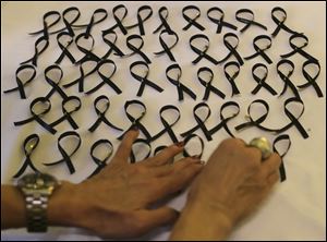 Organizers arrange black ribbons during a ceremony in memory of passengers on board the missing Malaysia Airlines Flight MH370 in Kuala Lumpur, Malaysia Thursday.