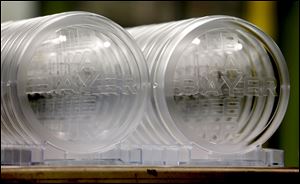 A row of polycarbonate disks are on display in front of where they were pressed at a research facility at the Bayer Corp. campus in Pittsburgh.