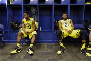 Michigan's Derrick Walton, Jr., left, and Zak Irvin process the loss in the locker room. The Wolverines finish the season with a record of 28-9.