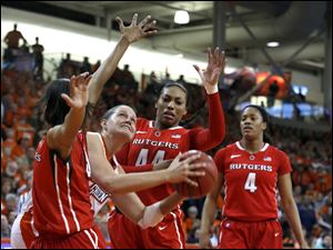 BGSU senior Jill Stein goes up between Rutgers' Tyler Scaife, left, and Betnijah Laney tonight at Stroh Center in Bowling Green.