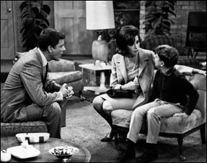From left, Dick Van Dyke, as Rob Petrie, and Mary Tyler Moore, as Laura Petrie, talk to Larry Matthews, who plays their son, Ritchie, on 
