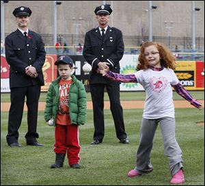 Grace Hoye, 8, niece of fallen firefighter Stephen Machcinski, throws out one of the first pitches. Mr. Machcinski’s nephew Brandon Hoye waits by her.