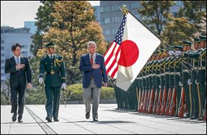U.S. Secretary of Defense Chuck Hagel, right, reviews honor guards accompanied by Japanese Defense Minister Itsunori Onodera, left, in Tokyo on Sunday.