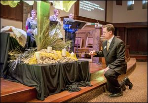 The Rev. Jeff Miller lights four candles, one for each of the victims of the Fort Hood shooting and one for the alleged shooter, at the start of worship at First United Methodist Church in Killeen, Texas.