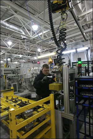 Jeff Roe of Oregon puts the valve guides into a six-speed transmission at the Toledo plant on Alexis Road. The line on which he works has been extended to allow the production of both six and eight-speed transmissions on the same line.