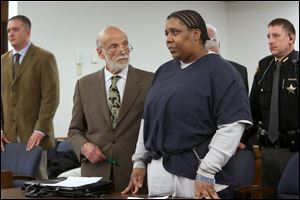 Kenya McGhee, 39, center, cries as she listens to a victim impact statement read by Mary Haynes, the daughter of Olandia Keith Dixon, not pictured, during sentencing proceedings today in the Lucas County Courthouse.