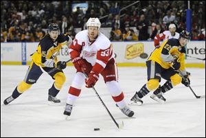 Detroit Red Wings' Johan Franzen (93), of Sweden, skates between Buffalo Sabres' Brian Flynn (65) and Johan Larsson (22) during the second period.