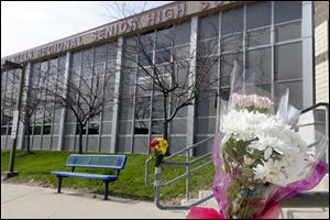 A bouquet of flowers is taped to a stairway rail near the closed entrance to Franklin Regional High School near Pittsburgh, Thursday in Murrysville, Pa.