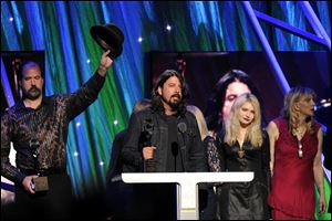 Hall of Fame Inductee of Nirvana, Dave Grohl speaks to the crowd. The groups' bassist Krist Novoselic, left, acknowledges the crowd.
