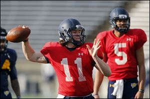 University of Toledo football player Logan Woodside (11) throws as  Michael Julian (5) watches during practice at the Glass Bowl.