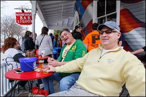 Jordan Davenport, left, and his brother Jerry Davenport, both of Catawba Island, kick back on the deck at the Round House Bar in Put-in-Bay, Ohio.  A few hours before the whiskey light glowed, Jordan Davenport put the day’s festivities into a snapshot perspective: When the sign goes on, it’s the ‘beginning of summer.’