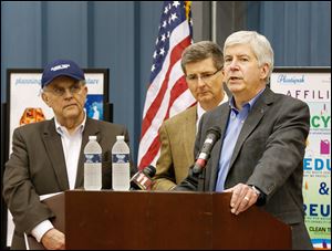 Michigan Gov. Rick Snyder, right, accompanied by Bill Young, CEO of Plastipak Packaging, left, and Dan Wyant, director of the Michigan Department of Environmental Quality, announced on Monday in Dundee, Mich., a statewide effort to double the amount of residential recycling. 