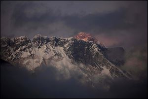 The last light of the day sets on Mount Everest as it rises behind Mount Nuptse as seen from Tengboche, in the Himalaya's Khumbu region, Nepal in October, 2011.