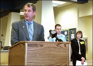 U.S. Sen. Sherrod Brown, left, talks to Perrysburg High students about student loan costs on Monday. Behind him is Owens graduate Kelly McVicker, center, and Michelle Simmons, BGSU vice president of enrollment management.