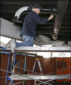 Dan Shepherd of Monarch Investment paints duct work for the new wine bar. that's under construction inside the Commodore Perry in Toledo.