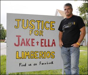 Mike Limberios, farther of Jake Limberios,  in front sign on a residential lawn in Fremont, Ohio. The signs are for a campaign called Justice for JAKE.