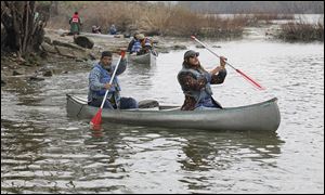 David Greene, left, and his son, Rowan, a member of Save Maumee, begin to navigate their canoe Friday down the Maumee River at Grand Rapids, Ohio. The group said 16 members were set to pad-dle the entire way from Fort Wayne, Ind., to International Park in downtown Toledo.