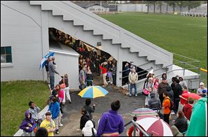 Waite High students gather under the seats of the school’s Mol-lenkopf Stadium  in response to a reported bomb threat Friday.