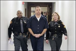 Tom Noe, flanked by Lucas County sheriff’s deputies, leaves a courtroom after sentencing in this 2006 photo.