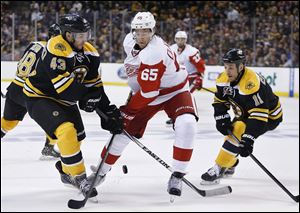 Boston Bruins' Matt Bartkowski (43) and Detroit Red Wings' Danny DeKeyser (65) battle for the puck during the first period in Game 5 in the first round of the NHL hockey Stanley Cup playoffs