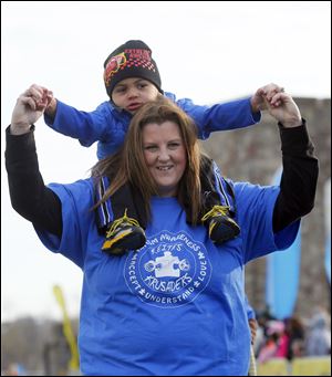 Keith Davis, 3, who has autism, sits on the shoulders of his mom, Amanda Davis of Genoa, near the finish line. The two raised funds for ‘Keith’s Krusaders’ in the national event called ‘Walk Now for Autism Speaks.’