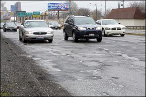 Pot holes on the Anthony Wayne Trail on the south bound lanes near City Park on April 28, 2014.