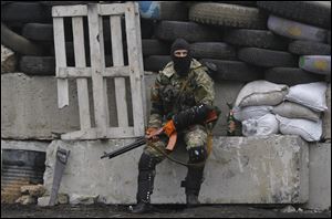 A pro-Russian masked armed militant guards barricades near Slovyansk, eastern Ukraine, today. 