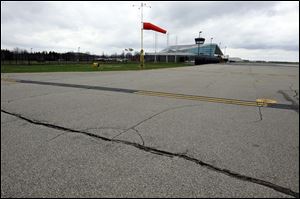Cracks mar the runway at Oakland County International Airport in Waterford, Mich. show what repairs are needed that would be funded by the increased aviation fuel tax.