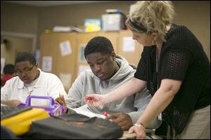 Teacher Tracey Johnson helps eighth-grader Demarko Craig prepare for an upcoming test at Chase STEM Academy. The school expelled Demarko last year for discipline problems. This year is different.