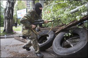 A Pro-Russian gunman runs behind barricades holding a weapon in Slovyansk, eastern Ukraine today.
