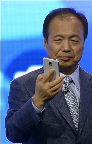 Samsung CEO J.K. Shin presents the new Samsung Galaxy S5 at the Mobile World Congress mobile phone trade show in Barcelona. The S5 is 5.6 by 2.85 inches and weighs 5.11 ounces.