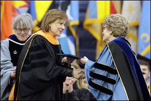 General Motors CEO Mary Barra, left, is conferred an honorary Doctor of Engineering degree by Michigan President Mary Sue Coleman, before addressing UM graduates.