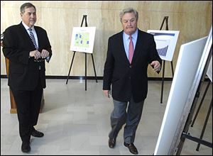 U.S. Census Bureau Director John Thompson, left, looks on as North Dakota Gov. Jack Dalrymple shows him one of the charts illustrating large growth in North Dakota counties during a news conference.