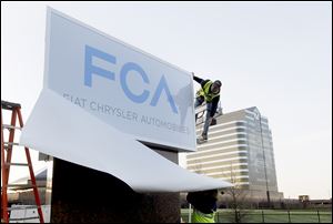 The Fiat Chrysler sign is unveiled at Chrysler World Headquarters in Auburn Hills, Mich.
