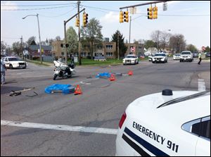 Toledo police block the intersection of the Anthony Wayne Trail and South Avenue today after a truck dropped a couple of steel coils on the roadway. 
