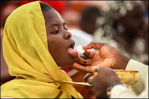 Catholic faithful take Holy Communion and pray for the safety of the kidnapped Chibok school girls during a morning Mass in honor of the girls in Abuja, Nigeria.